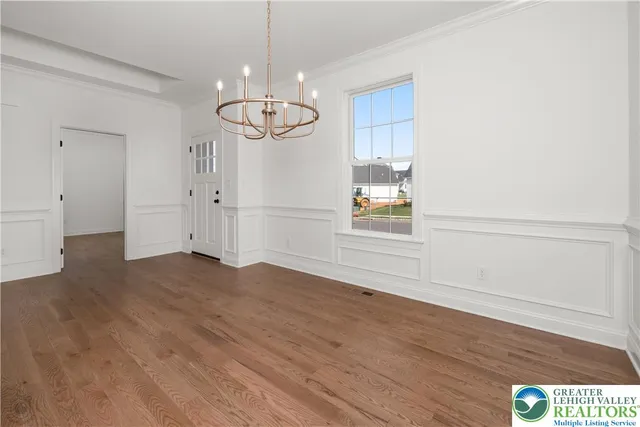 a view of empty room with wooden floor and window