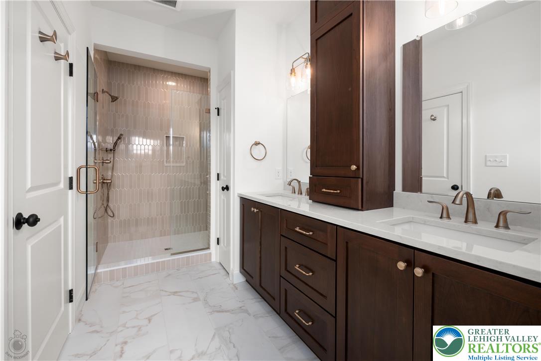 4268 Stonebridge Drive Bethlehem, PA 18015 - Photo 25 of 37 a bath room with a sink double vanity large mirror and a shower