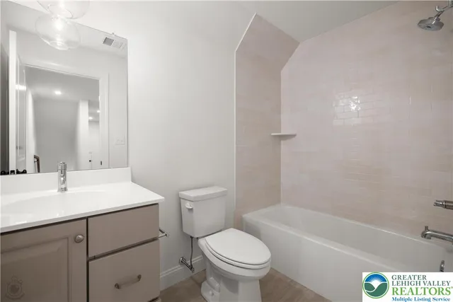 a bathroom with a sink toilet vanity and bathtub