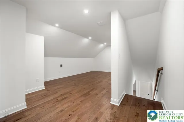 a view of hallway with a window and wooden floor