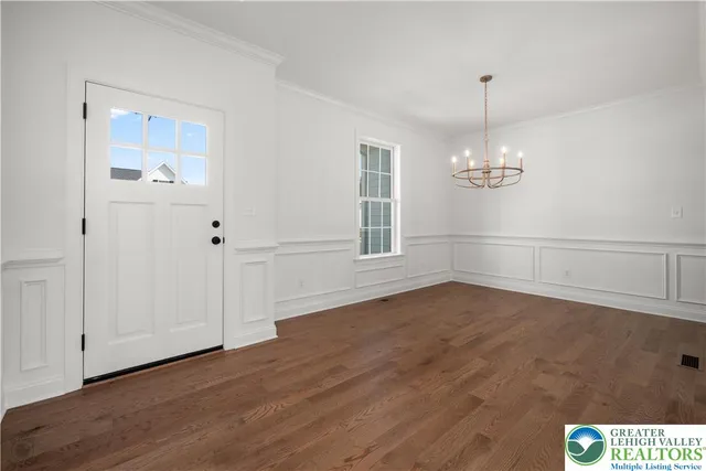 a view of empty room with wooden floor and window