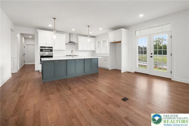 a view of kitchen with granite countertop stainless steel appliances cabinets and wooden floor
