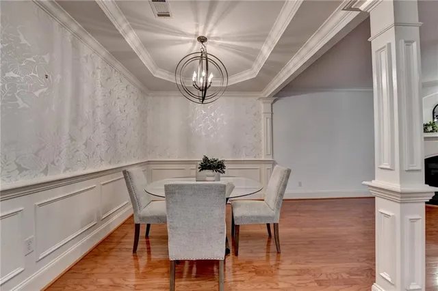 a kitchen with stainless steel appliances granite countertop a stove a sink dishwasher a refrigerator and white cabinets with wooden floor