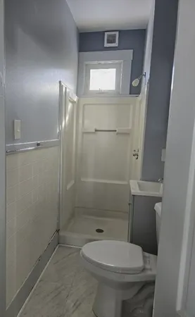 a bathroom with a toilet and a shower