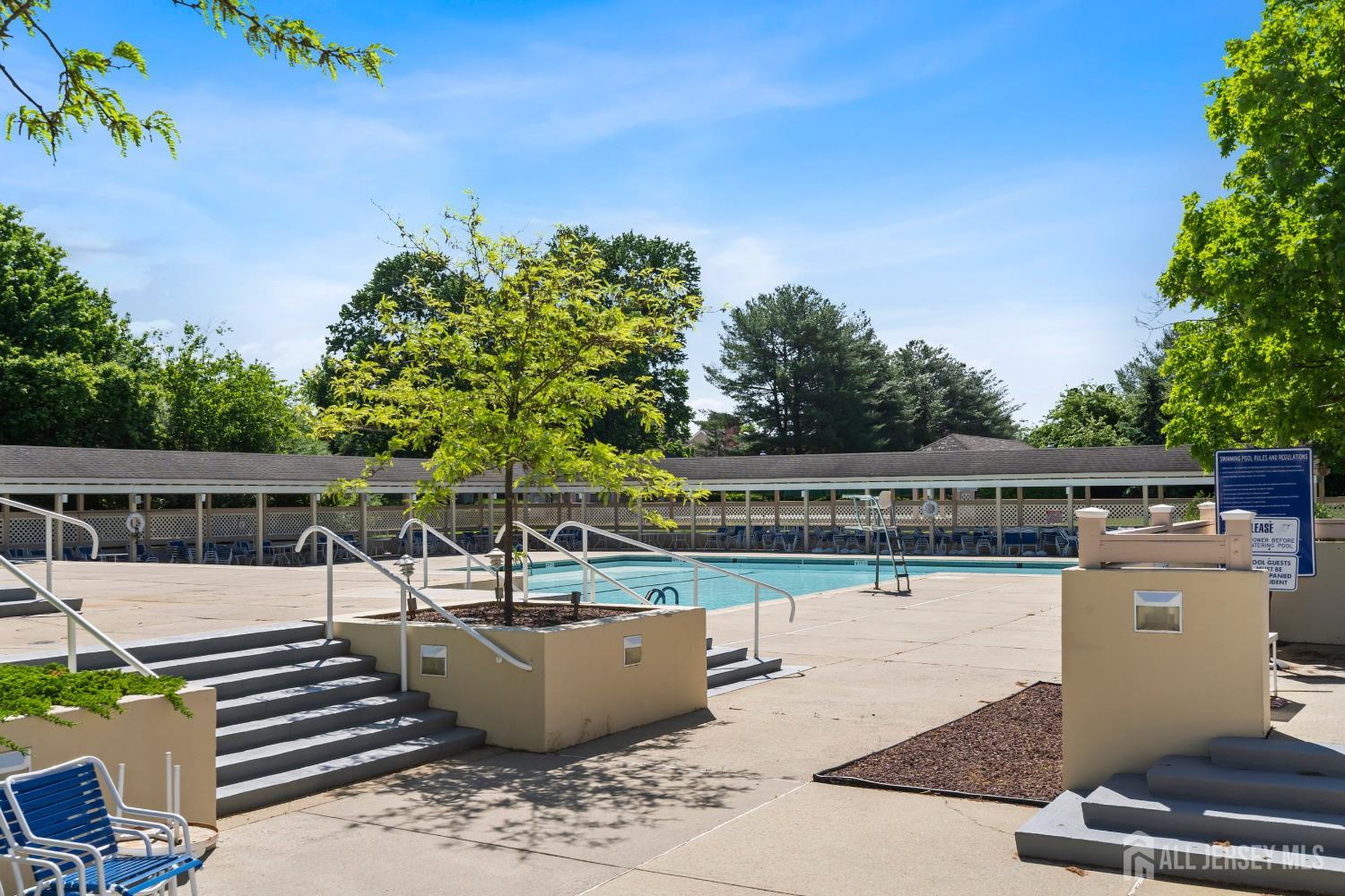 34 Rutland Lane, Unit B Monroe Township, NJ 08831 - Photo 33 of 45 a view of a swimming pool with a patio and wooden fence