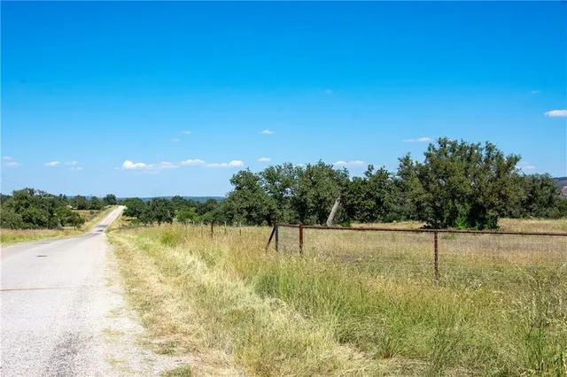 a view of lake with green field and trees