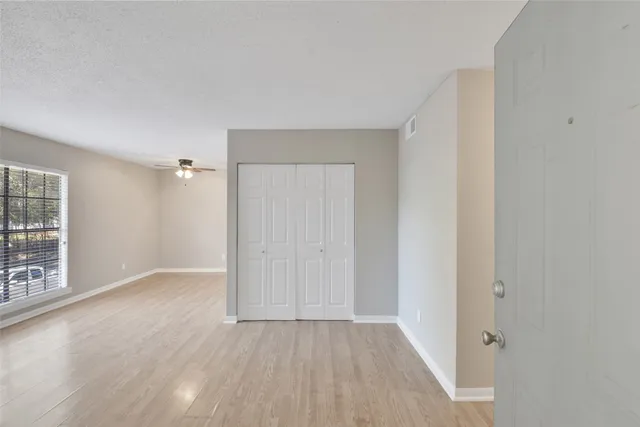 an empty room with windows and closet