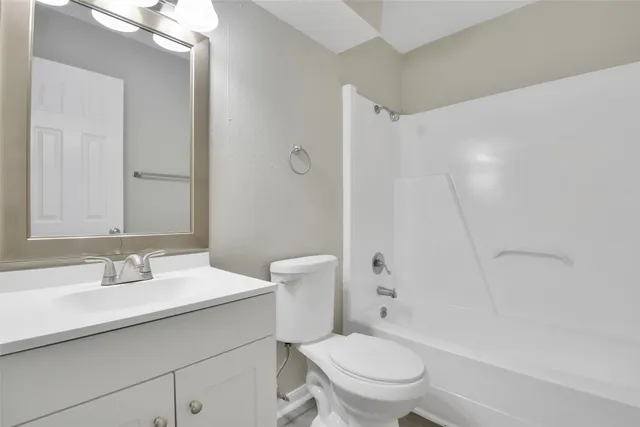 a bathroom with a sink toilet vanity and shower