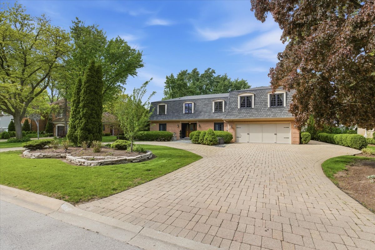 39 Mockingbird Lane Oak Brook, IL 60523 - Photo 3 of 57 a front view of a house with garden and trees
