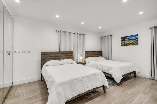 a bedroom with two beds and a night stand