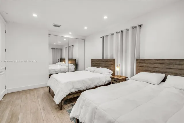 a bedroom with two beds and a night stand