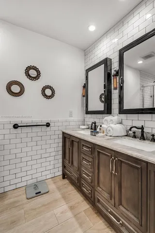 a bathroom with a double vanity sink mirror and toilet