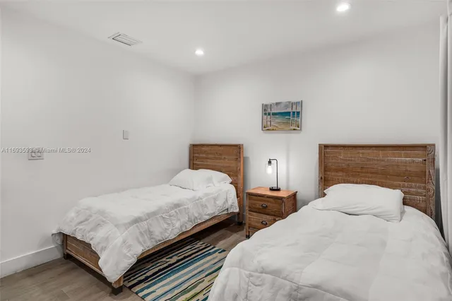 a bedroom with two beds and a lamp