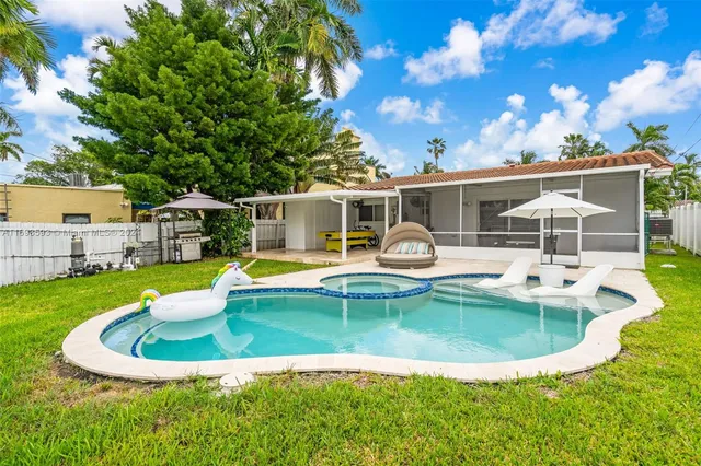 a view of a house with swimming pool and sitting area