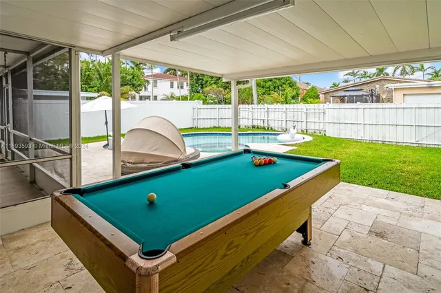 a room with pool table and windows