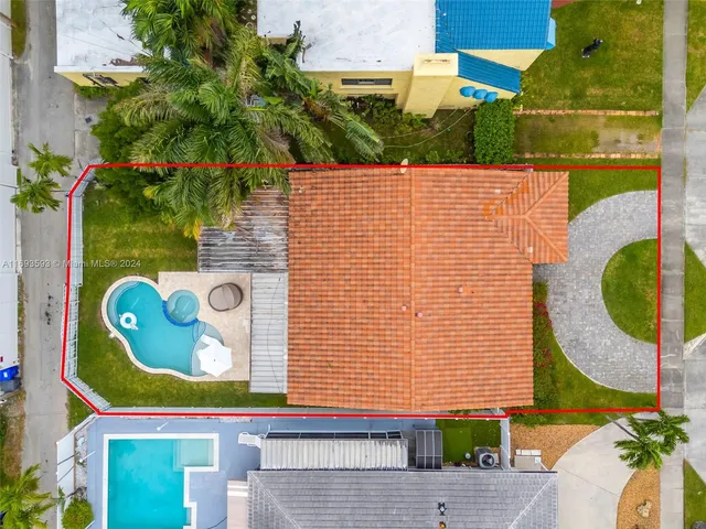 an aerial view of residential houses with outdoor space and trees