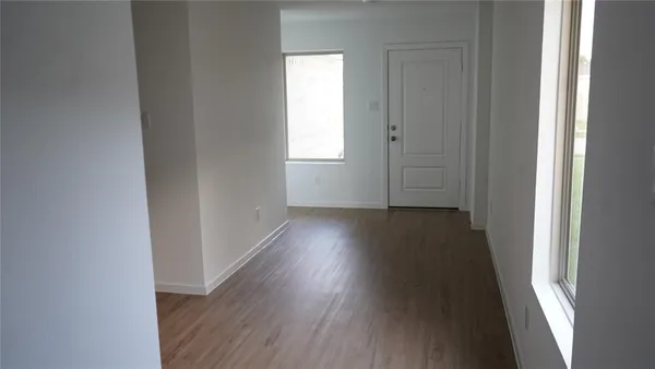a view of a hallway with wooden floor