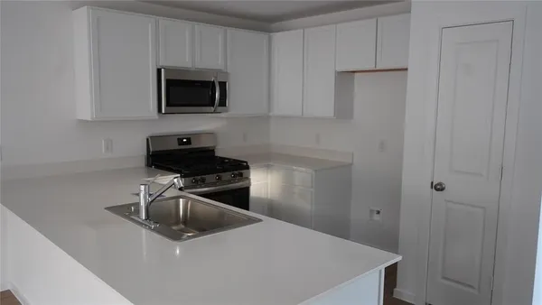 a kitchen with a sink and a stove top oven