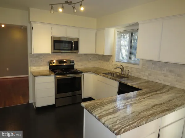 a kitchen with a sink stove and microwave