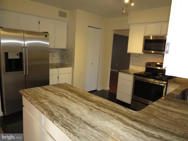 a kitchen with a refrigerator and a stove top oven