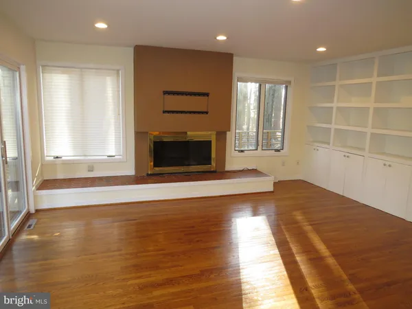 a view of an empty room with a fireplace and a window