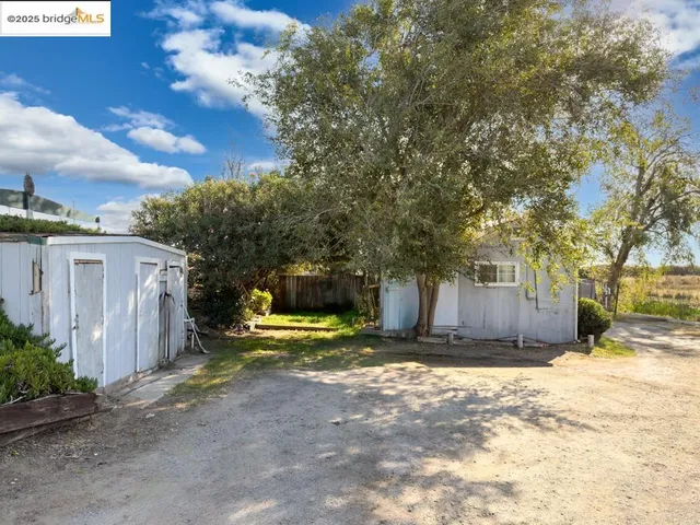 a view of a yard with wooden fence