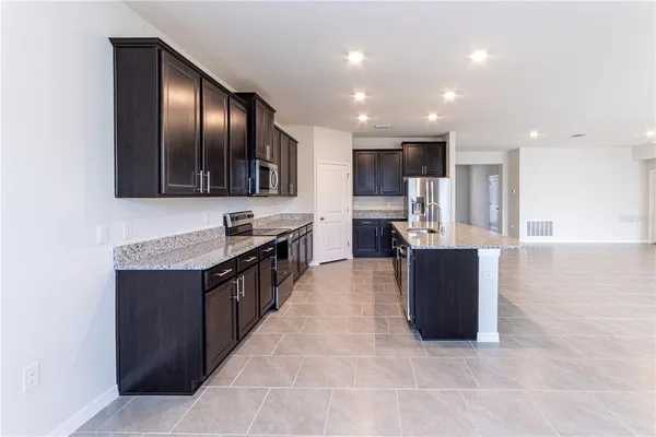 a kitchen with stainless steel appliances granite countertop a sink and a stove