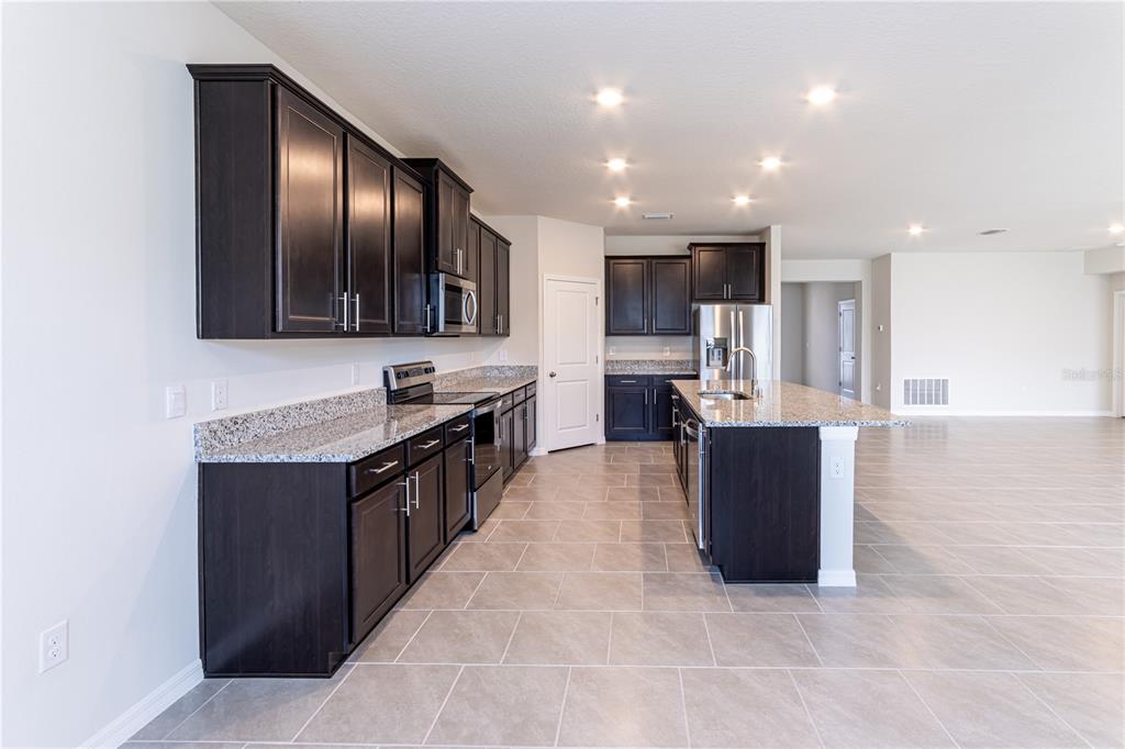 32183 Conchshell Sail Street Wesley Chapel, FL 33545 - Photo 18 of 45 a large kitchen with stainless steel appliances kitchen island granite countertop a large counter top and cabinets