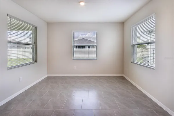 a view of kitchen with stainless steel appliances kitchen island and living room with a large window