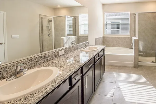 a spacious bathroom with a granite countertop sink and a bathtub