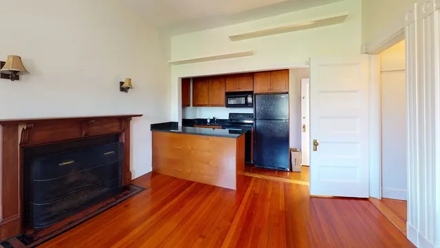 a kitchen with wooden floors and a fireplace