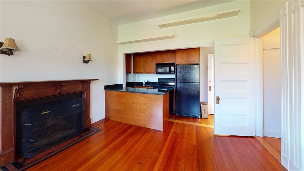 a kitchen with wooden floors and a fireplace