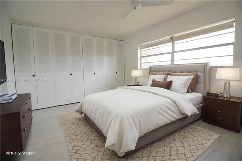a bedroom with a bed and a flat tv screen on dresser