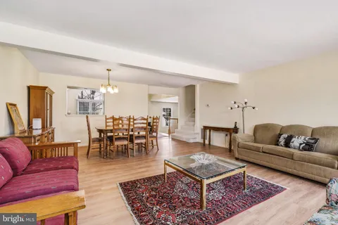 a living room with furniture a rug and a dining table