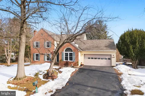 a view of a white house with a large tree in front of it
