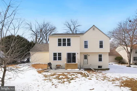 a view of a white house with a yard covered in snow