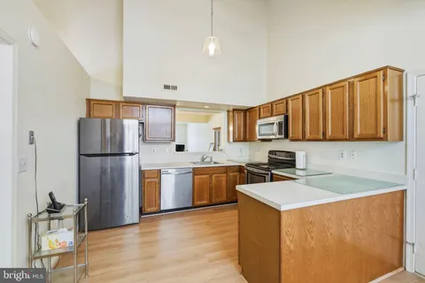 a kitchen with stainless steel appliances granite countertop a refrigerator stove top oven and sink