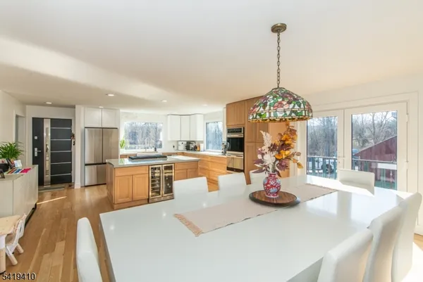 a view of a dining room and livingroom with furniture wooden floor a chandelier