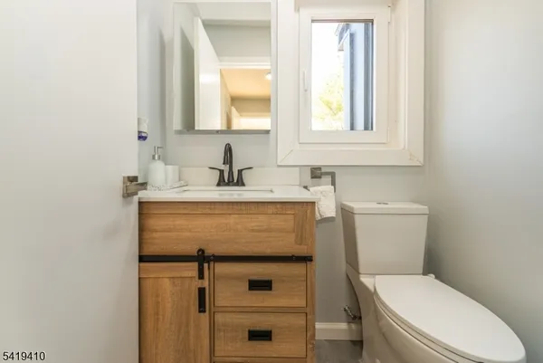 a bathroom with a sink a toilet and a mirror