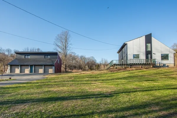 a view of a house with a big yard and large trees