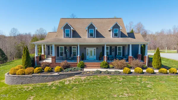 a front view of a house with a yard table and chairs in patio