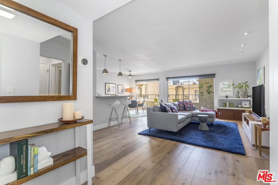 1221 North Kings Road, Unit 208 West Hollywood, CA 90069 - Photo 2 of 25 a living room with furniture flat screen tv and wooden floor