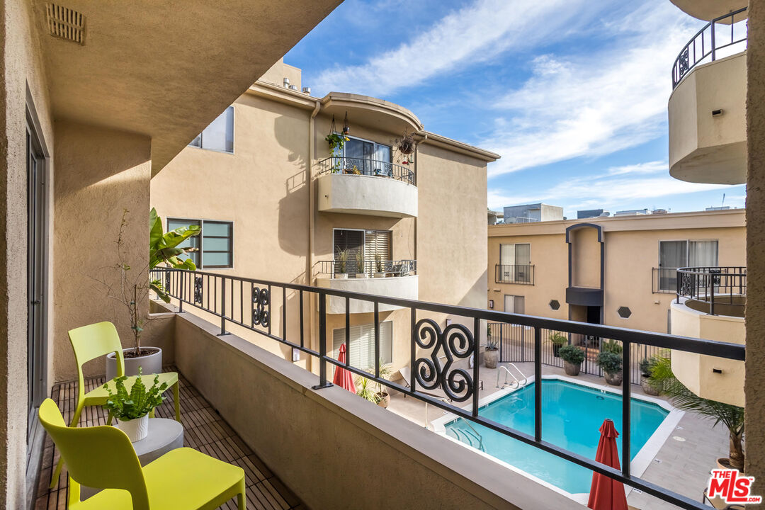 1221 North Kings Road, Unit 208 West Hollywood, CA 90069 - Photo 21 of 25 a view of a white house with a wooden deck