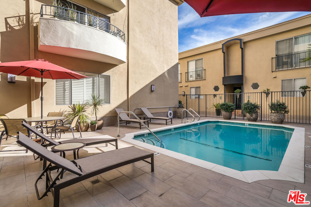 1221 North Kings Road, Unit 208 West Hollywood, CA 90069 - Photo 22 of 25 a view of a patio with swimming pool table and chairs