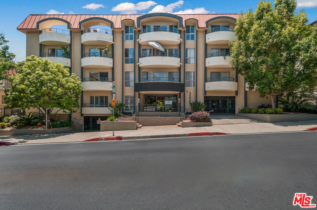 1221 North Kings Road, Unit 208 West Hollywood, CA 90069 - Photo 24 of 25 a group of cars parked in front of brick building