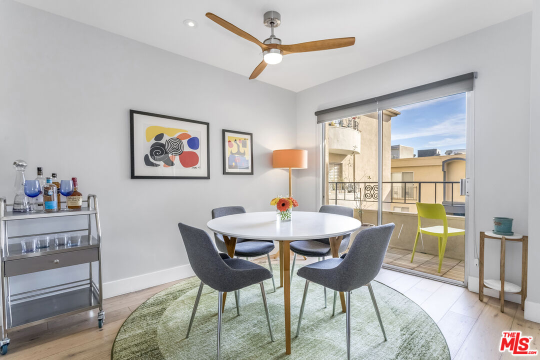 1221 North Kings Road, Unit 208 West Hollywood, CA 90069 - Photo 4 of 25 a dining room with furniture a rug and a floor to ceiling window