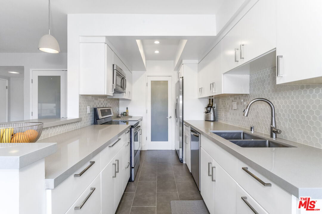 1221 North Kings Road, Unit 208 West Hollywood, CA 90069 - Photo 8 of 25 a kitchen with stainless steel appliances granite countertop a sink and cabinets
