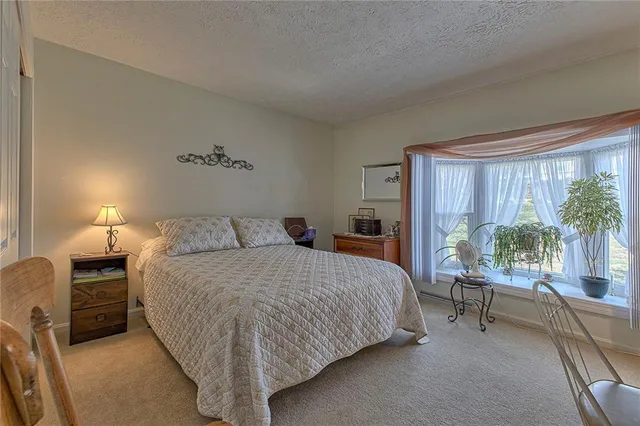 a bed sitting in a bedroom next to a window