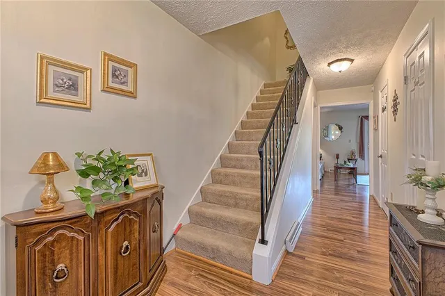a view of entryway and hall with wooden floor