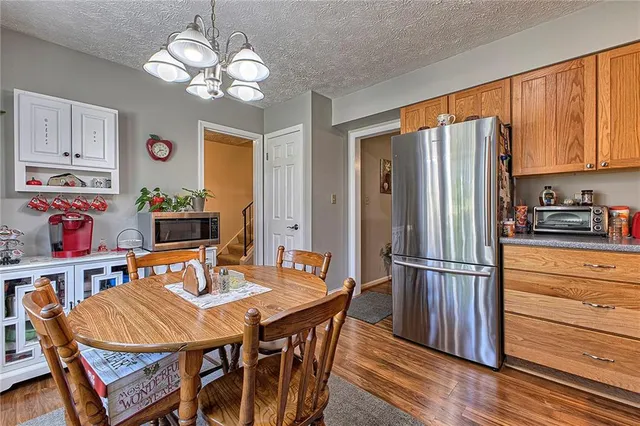 a kitchen with stainless steel appliances granite countertop a dining table and chairs